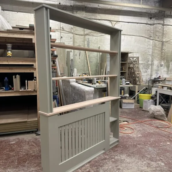 Bespoke white radiator cover with built-in side bookshelf and solid oak top in home office