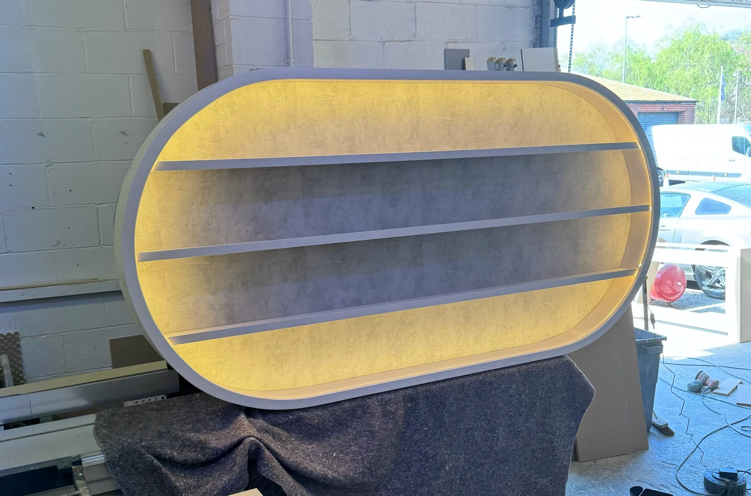 Salon LED Light Curved Oval Display in White with textured backing