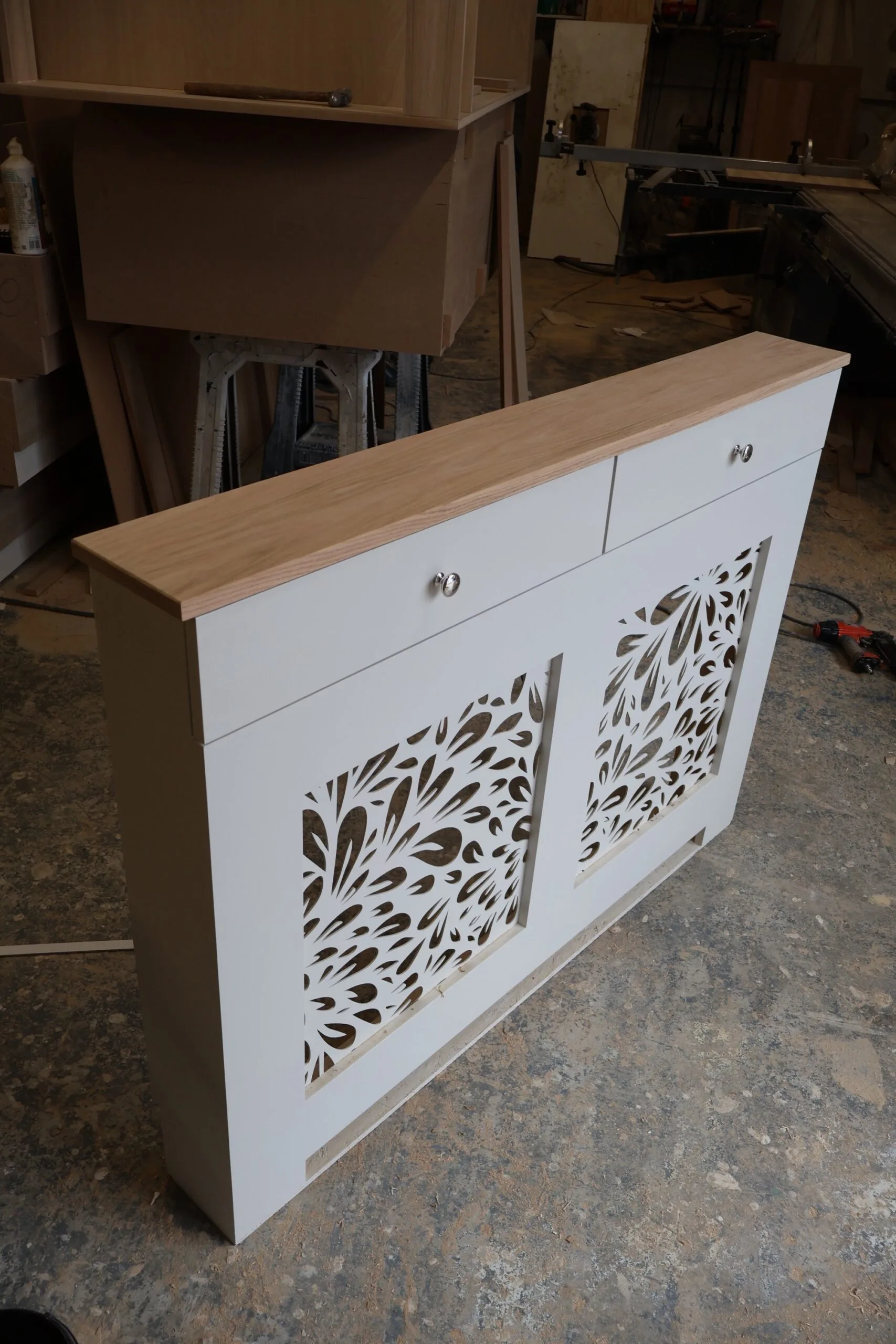 Bespoke white radiator cover with decorative floral grill pattern and natural oak top