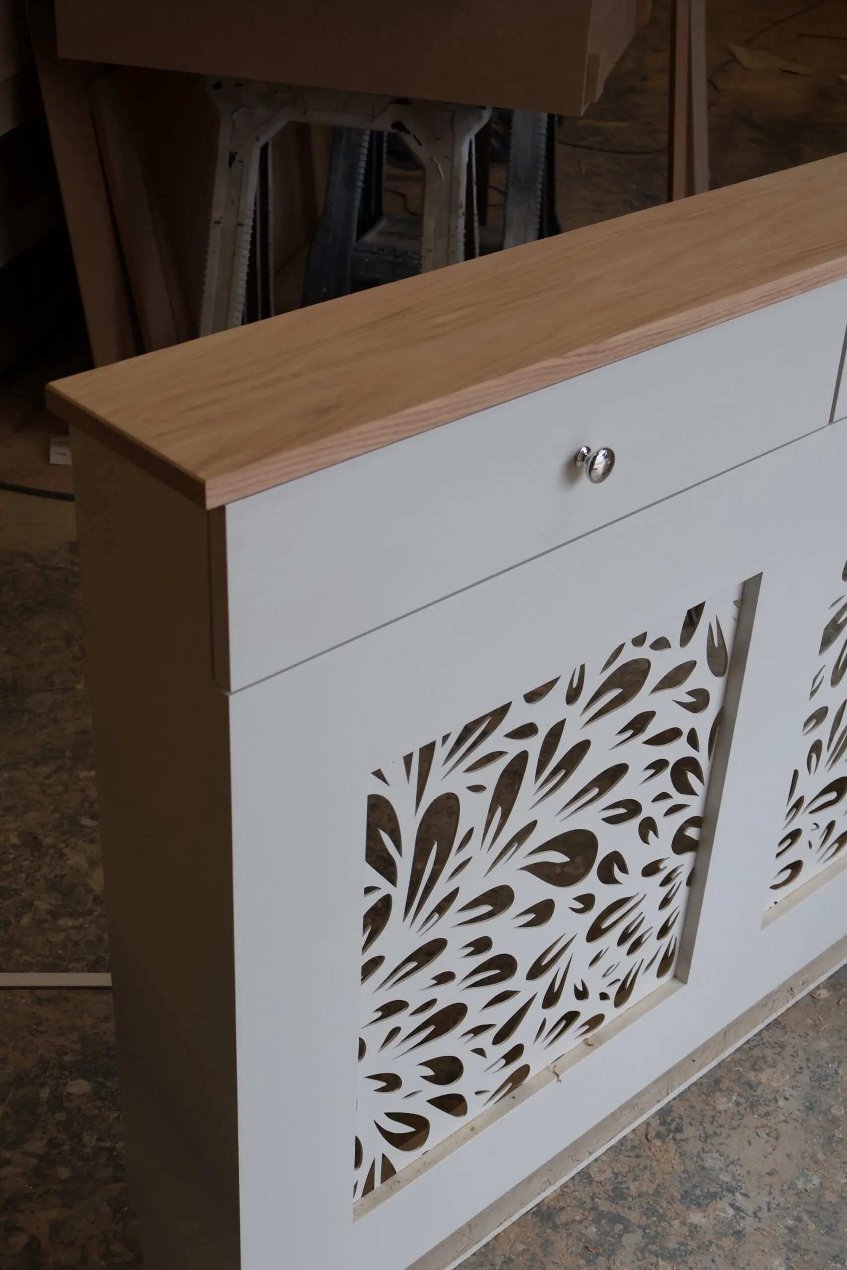Bespoke white radiator cover with decorative floral grill pattern and natural oak top