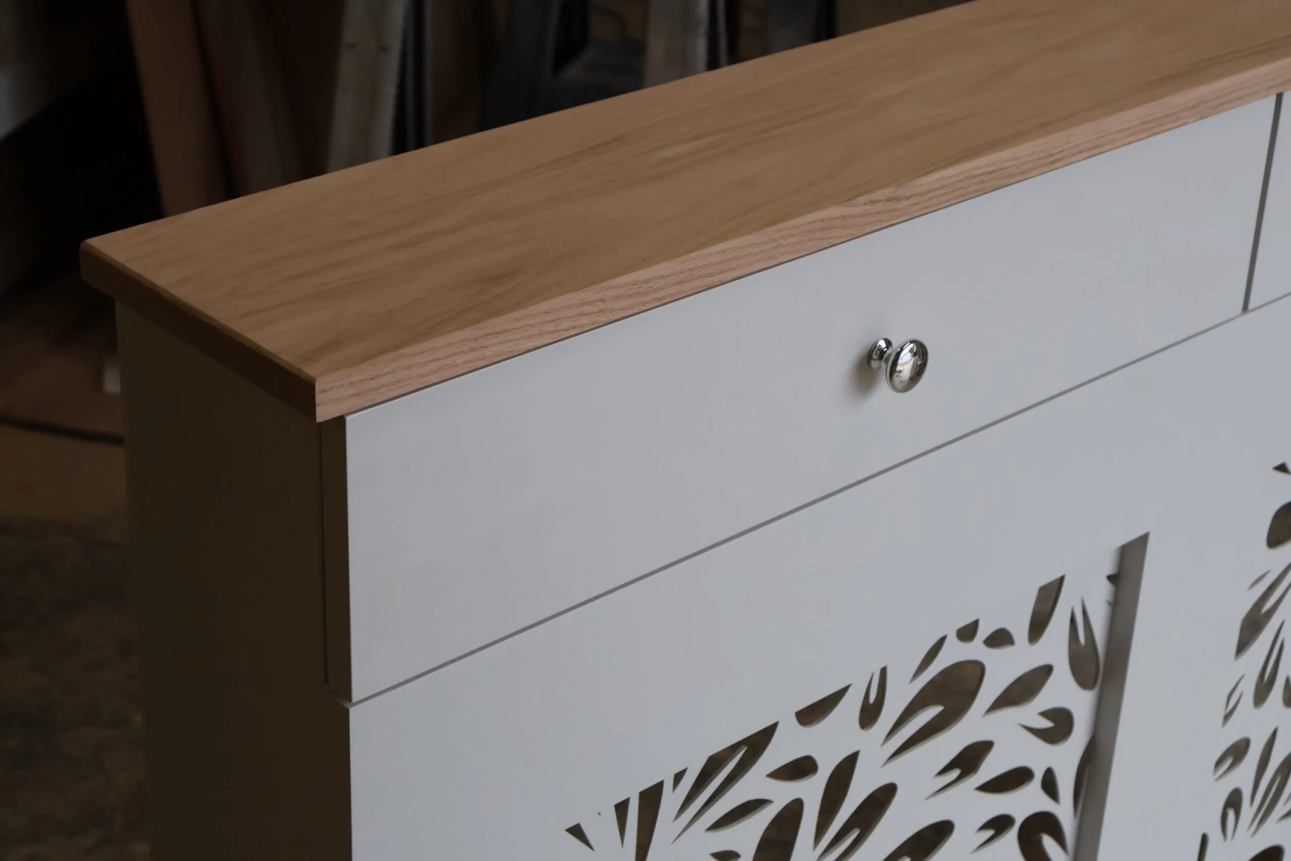 Bespoke white radiator cover with decorative floral grill pattern and natural oak top