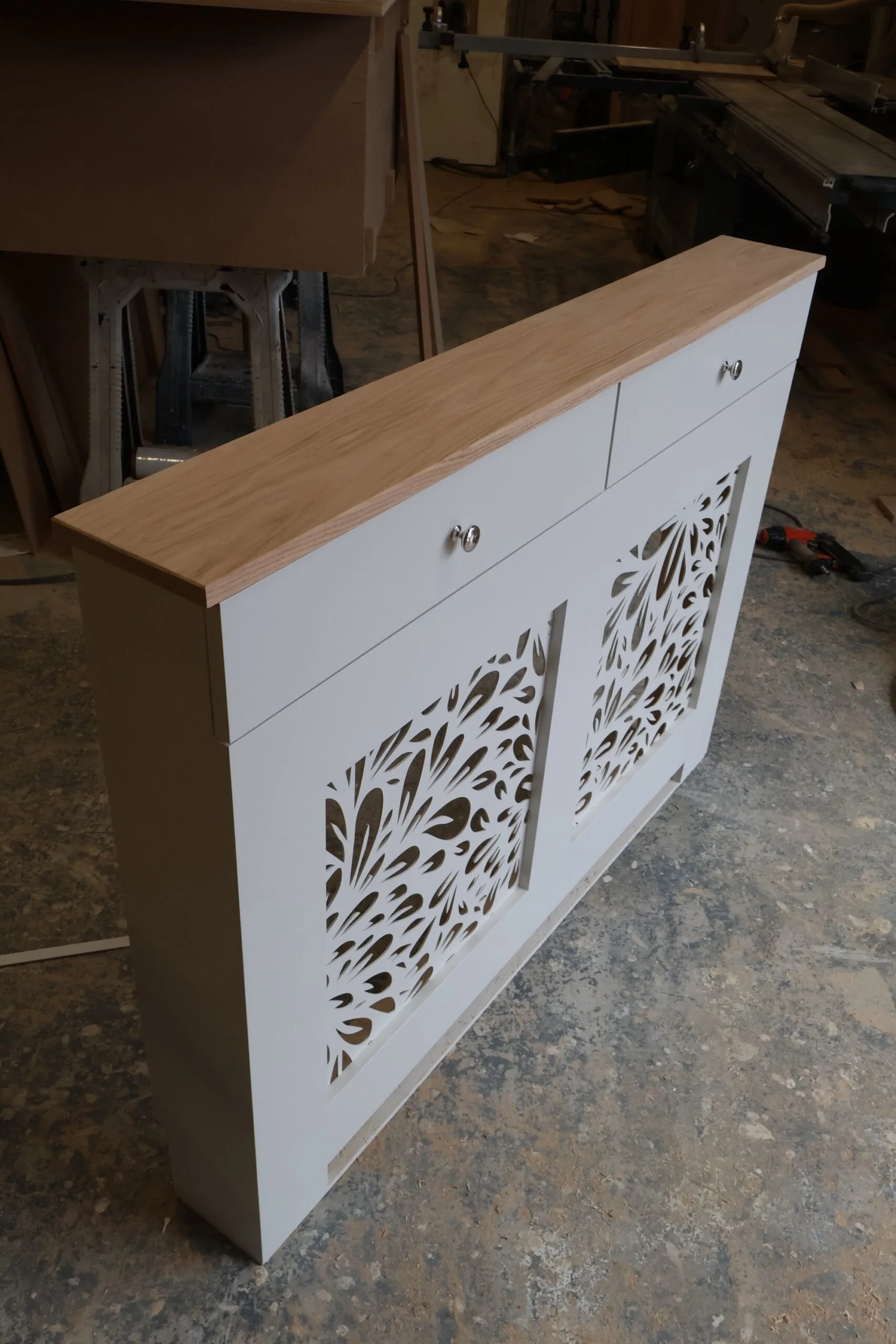 Bespoke white radiator cover with decorative floral grill pattern and natural oak top