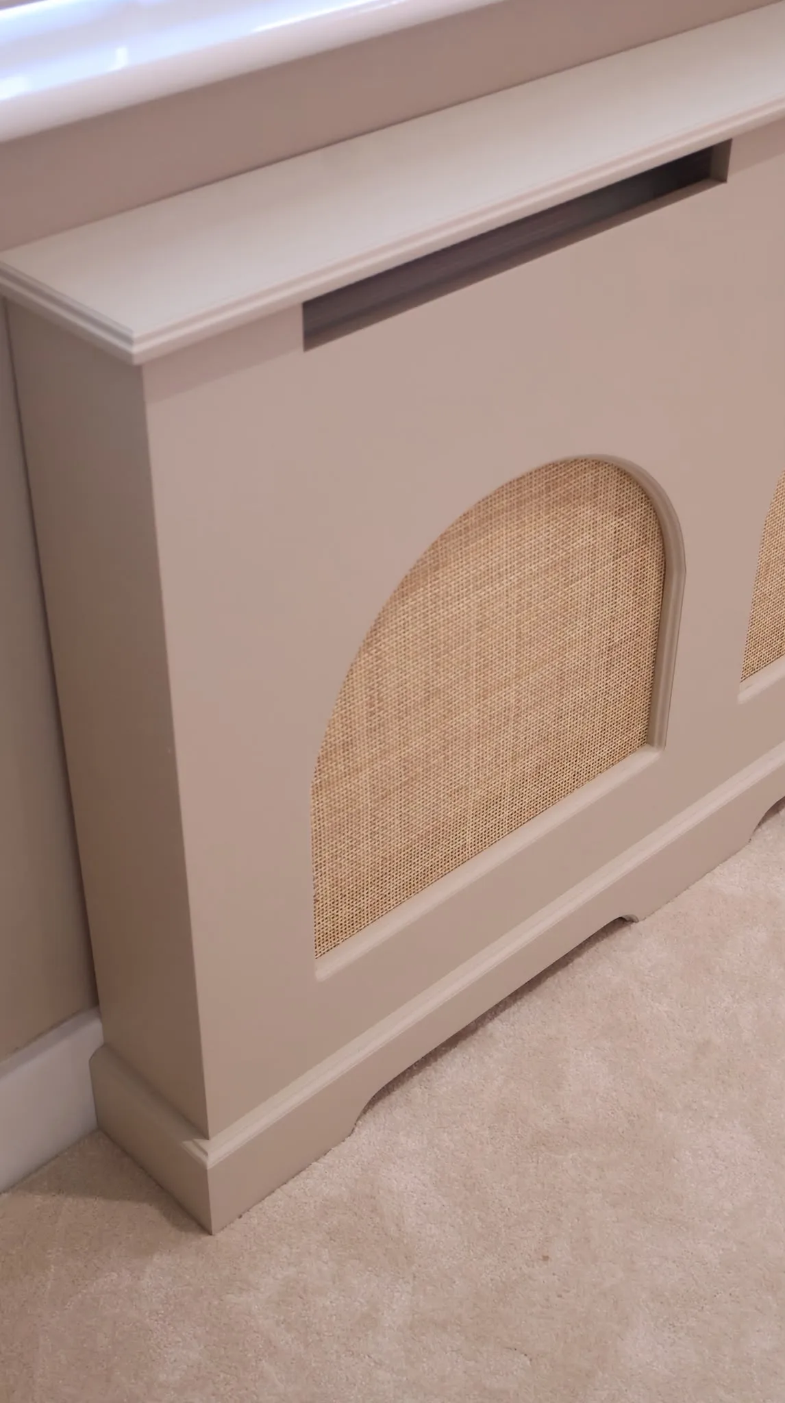 Bespoke radiator cover with curved rattan inserts in a soft neutral finish